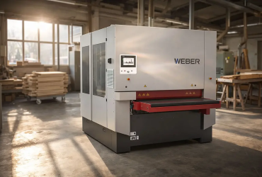 Large Weber woodworking machine in a workshop with stacks of wood and a safety control panel on the front rail.